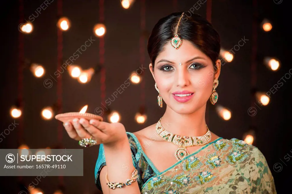 Woman holding an oil lamp on Diwali