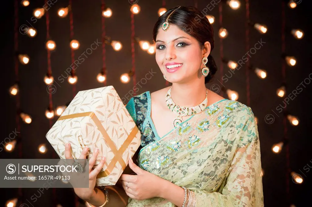 Woman holding a gift box on Diwali
