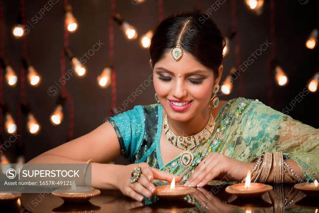 Woman looking at oil lamps on Diwali