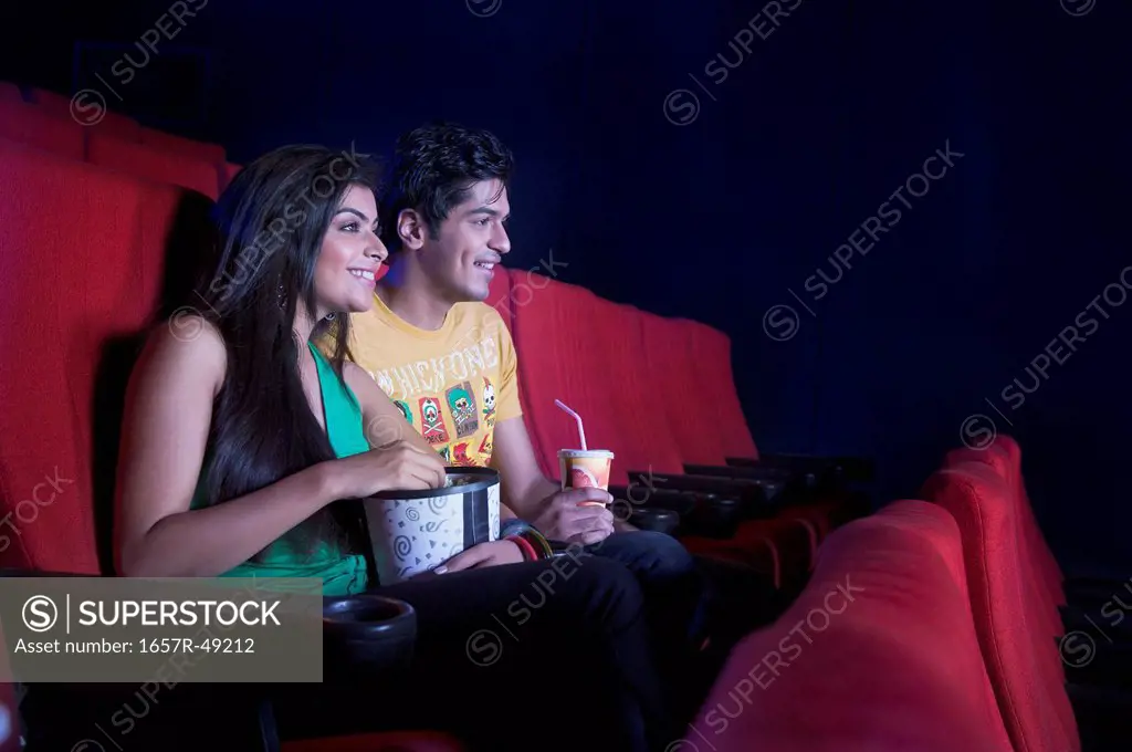 Couple enjoying movie in a cinema hall