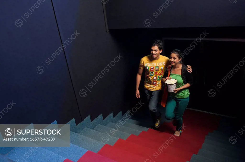 Couple moving up on steps in a cinema hall