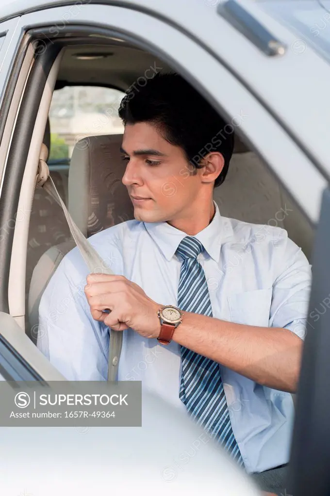 Businessman wearing seat belt in a car, Gurgaon, Haryana, India