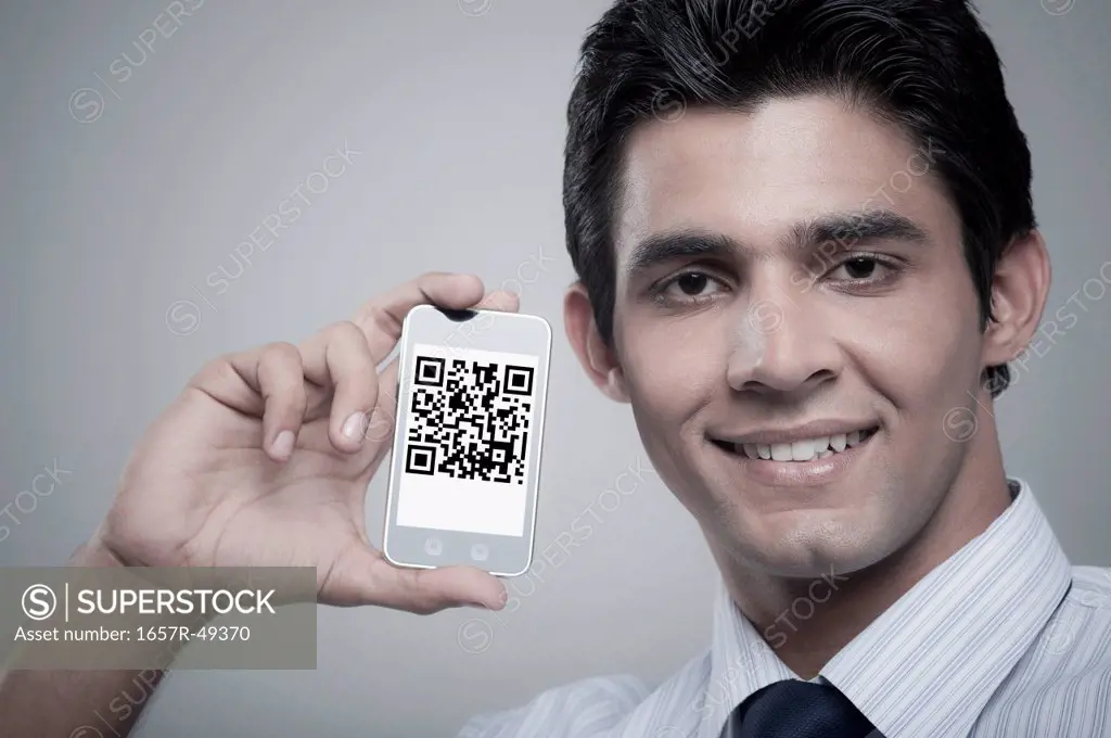 Businessman holding a mobile phone with 2D barcode on its screen
