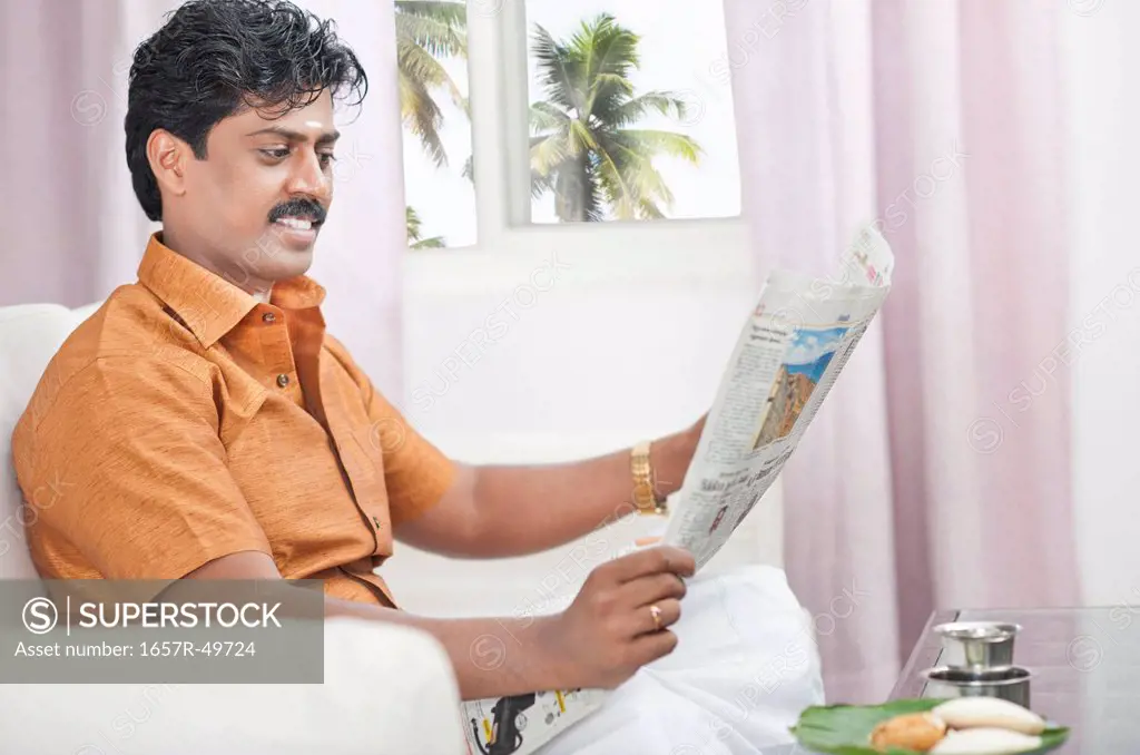 South Indian man reading a newspaper
