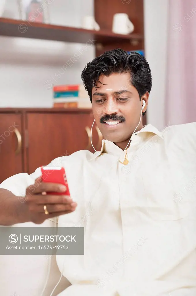 South Indian man listening to a mp3 player