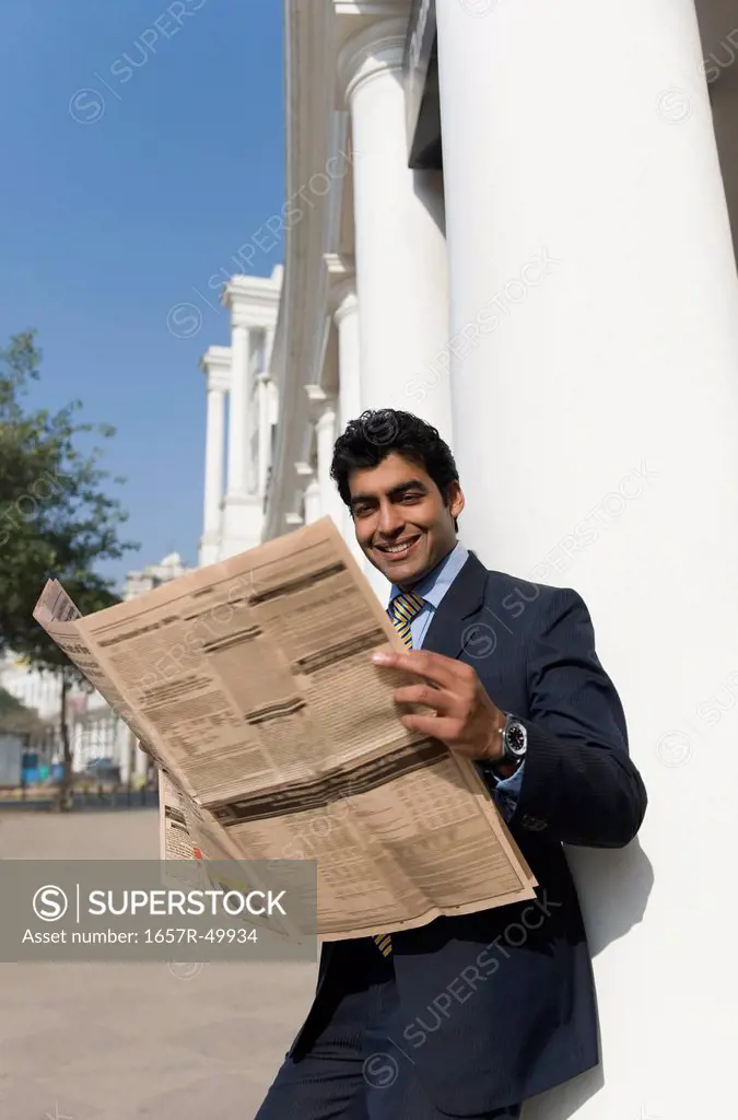 Businessman reading a newspaper, Gurgaon, Haryana, India