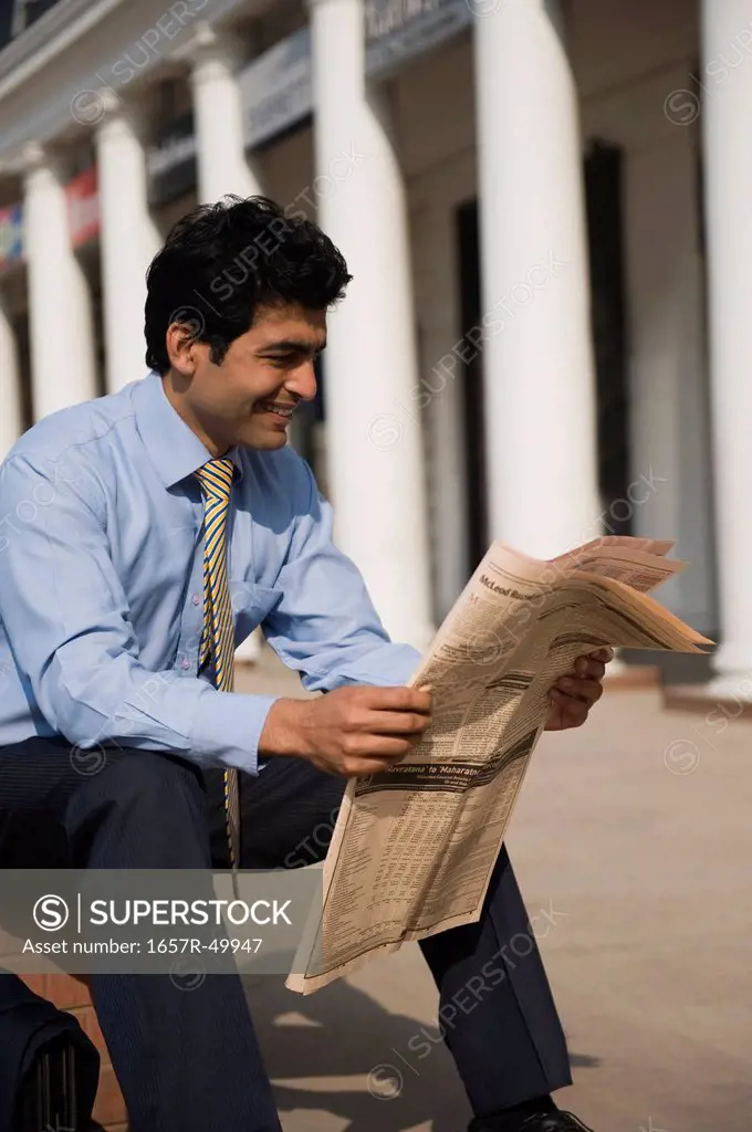 Businessman reading a newspaper, Gurgaon, Haryana, India