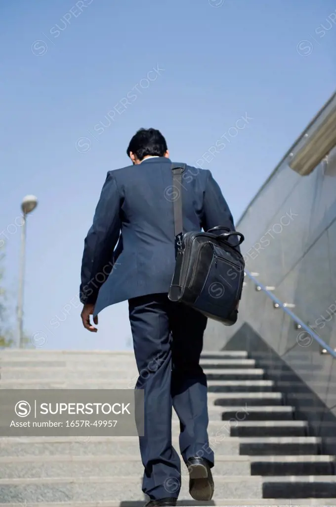 Businessman moving up stairs of subway, Gurgaon, Haryana, India