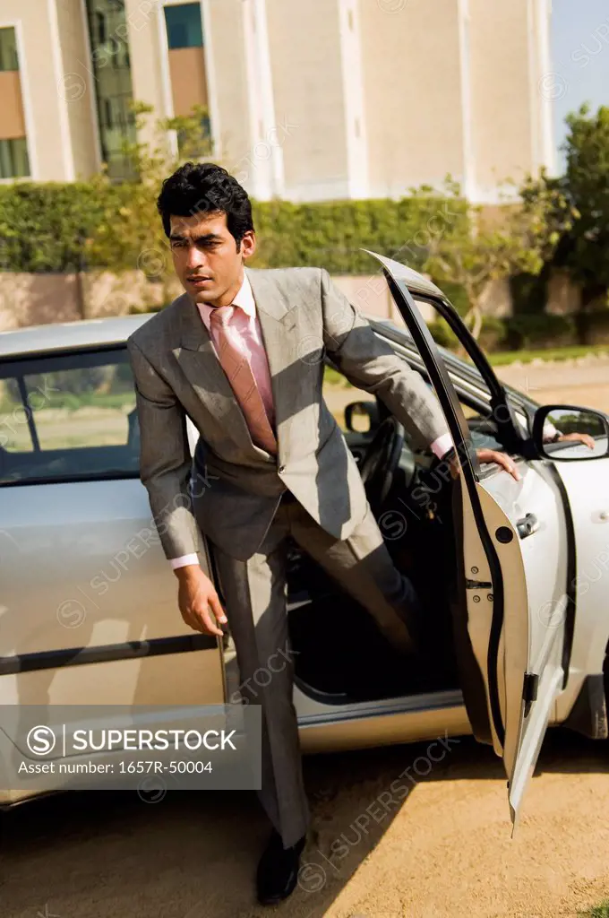 Businessman getting out of a car, Gurgaon, Haryana, India