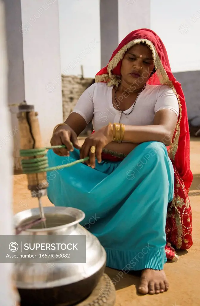 Woman churning butter, Farrukh Nagar, Gurgaon, Haryana, India