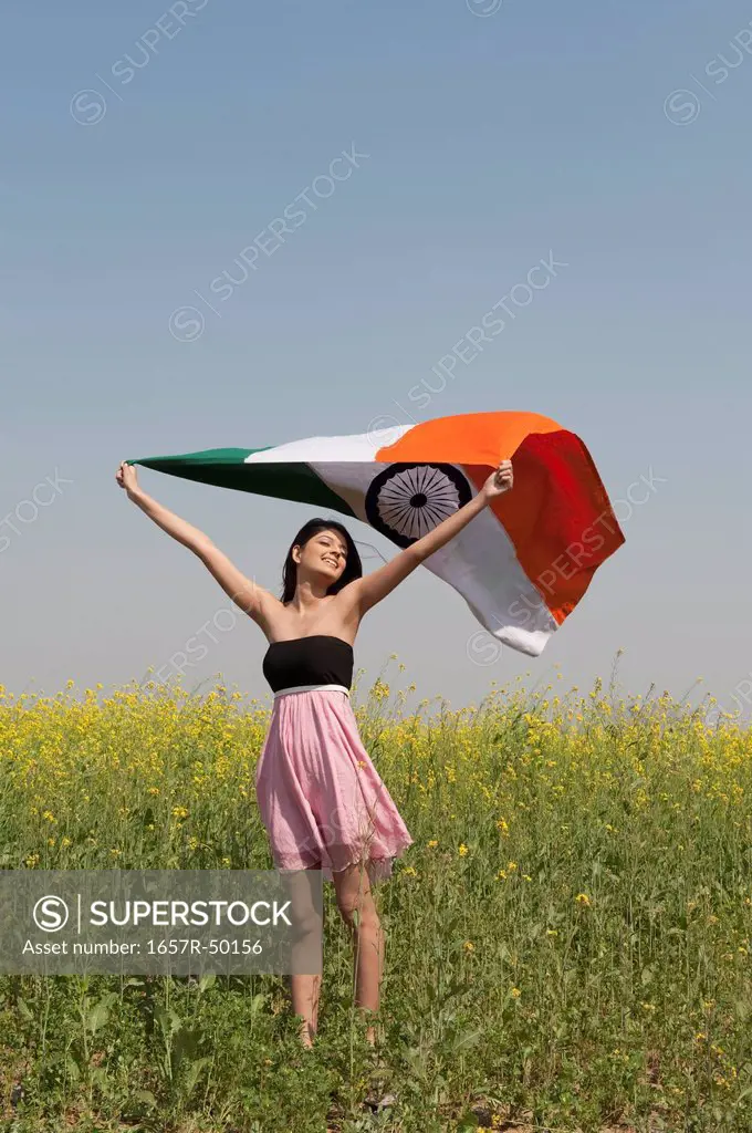 Woman holding an Indian flag in an oilseed rape field