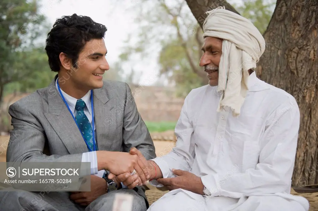 Financial advisor shaking hands with a farmer, Hasanpur, Haryana, India