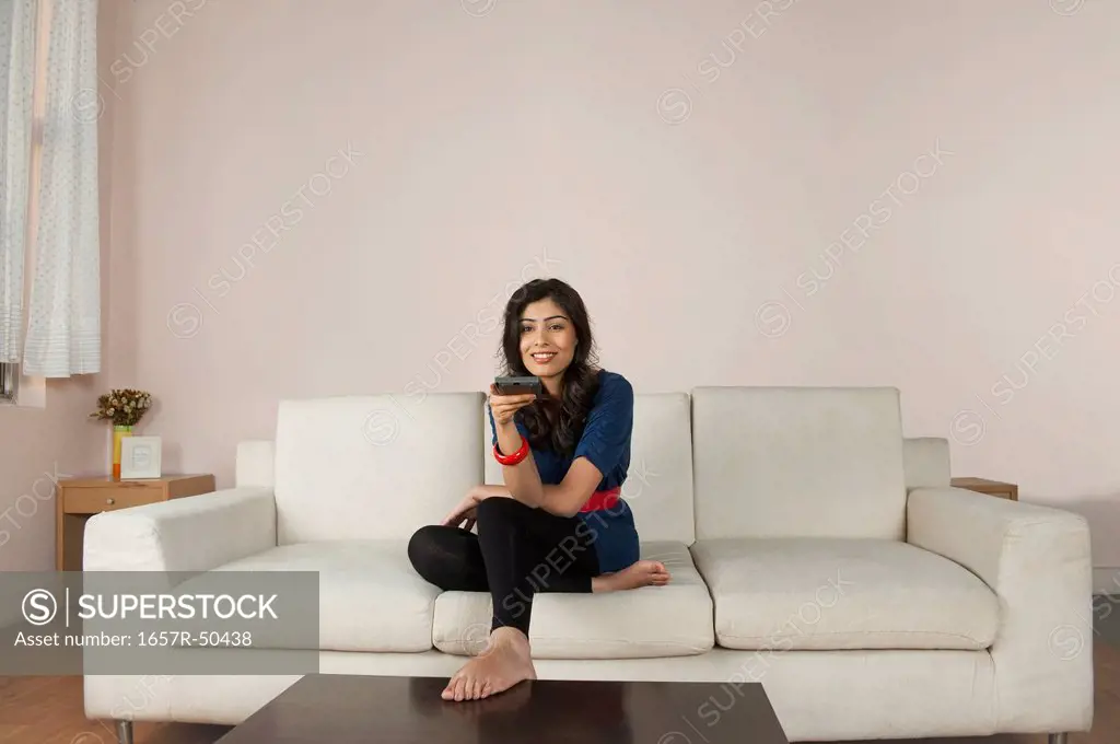 Woman operating a remote control while watching tv