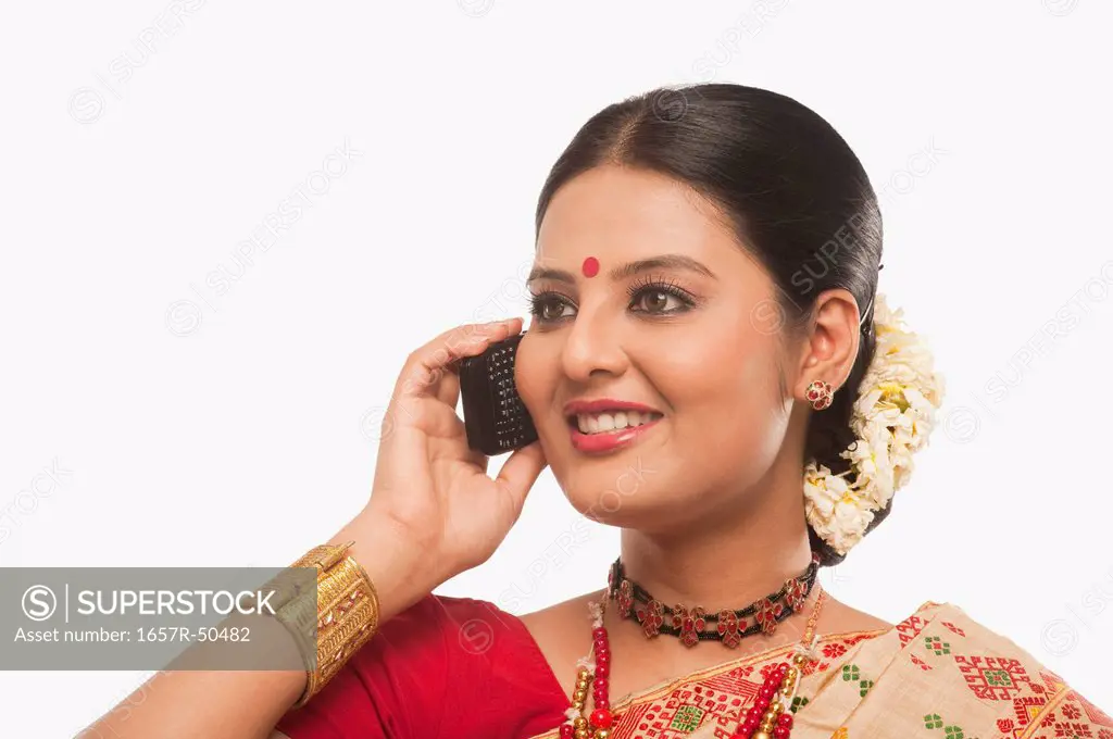 Close-up of a woman talking on a mobile phone in traditional clothing