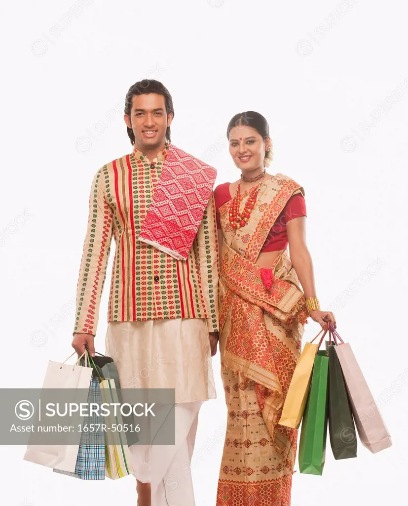 Portrait of a couple in traditional clothing holding shopping bags