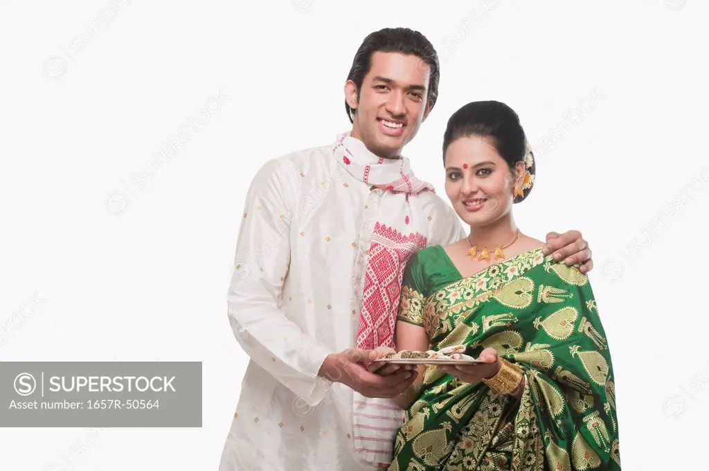 Portrait of a couple holding a plate of religious offerings