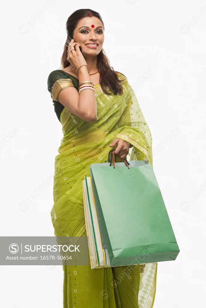 Bengali woman carrying shopping bags and talking on a mobile phone