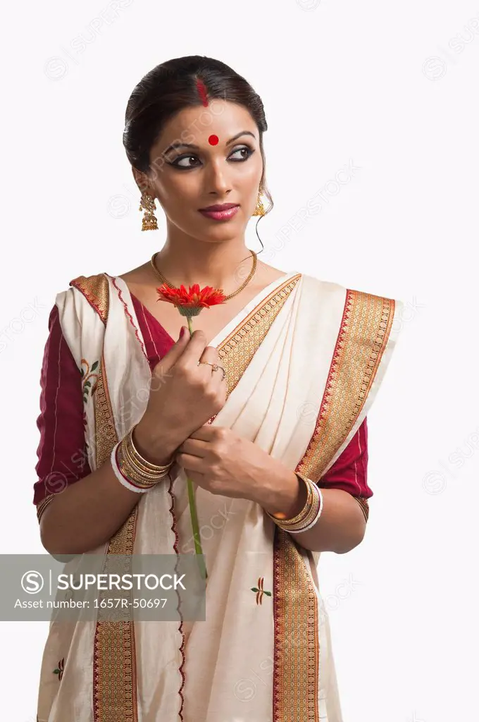 Bengali woman holding a Daisy flower and day dreaming
