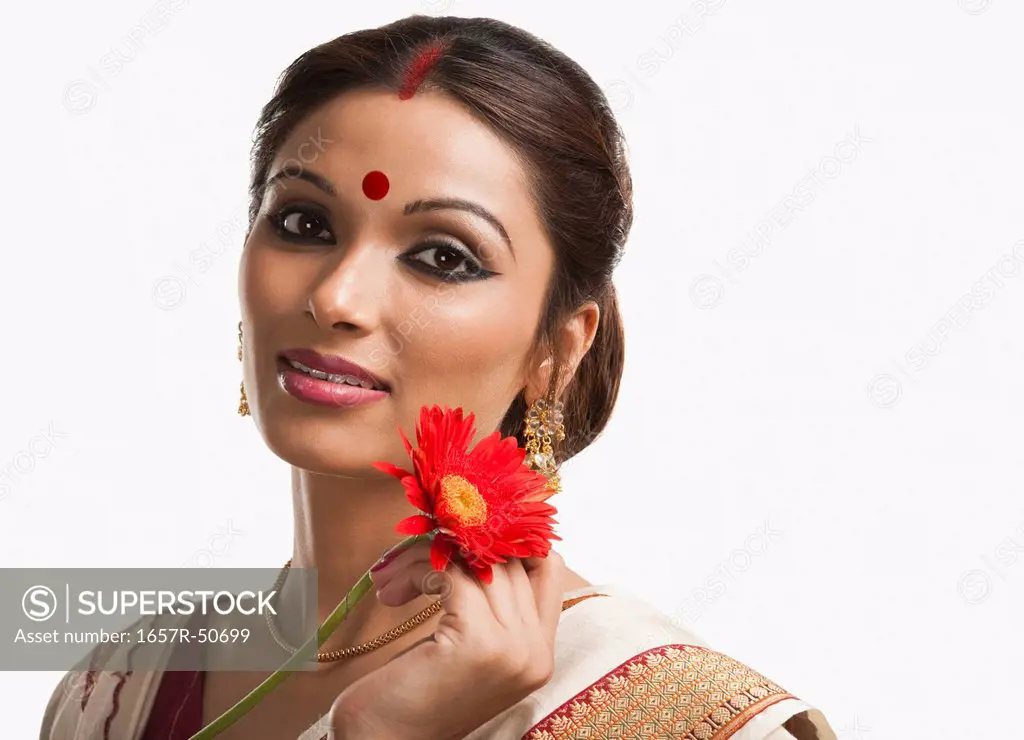 Bengali woman holding a Daisy flower and smiling