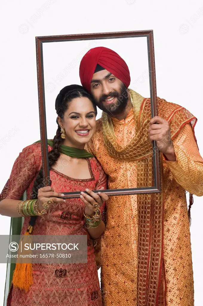 Sikh couple holding an empty picture frame