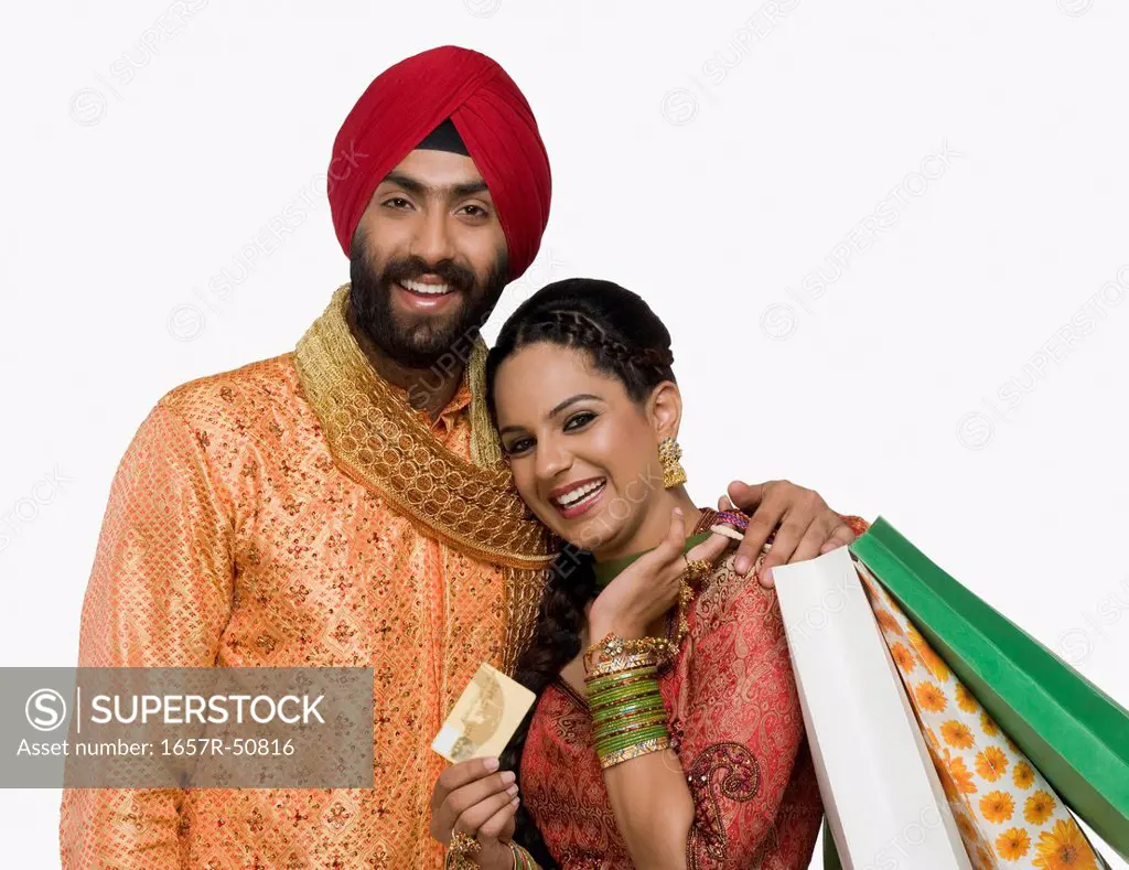 Sikh couple holding shopping bags and credit card