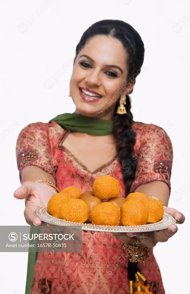 Woman holding a plate of laddu