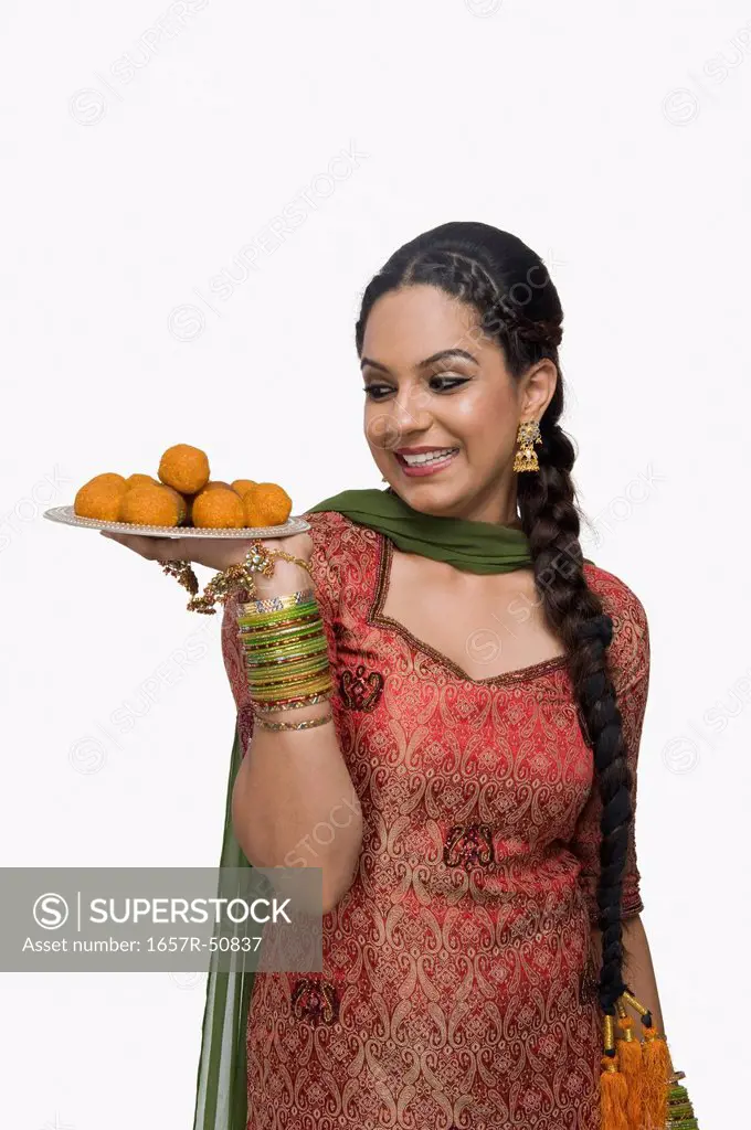 Woman holding a plate of laddu