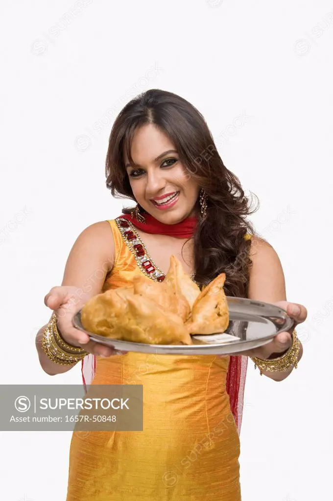 Woman holding a plate of samosa the traditional Indian snack