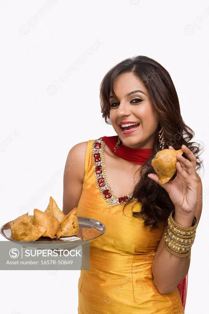 Woman holding a plate of samosa the traditional Indian snack
