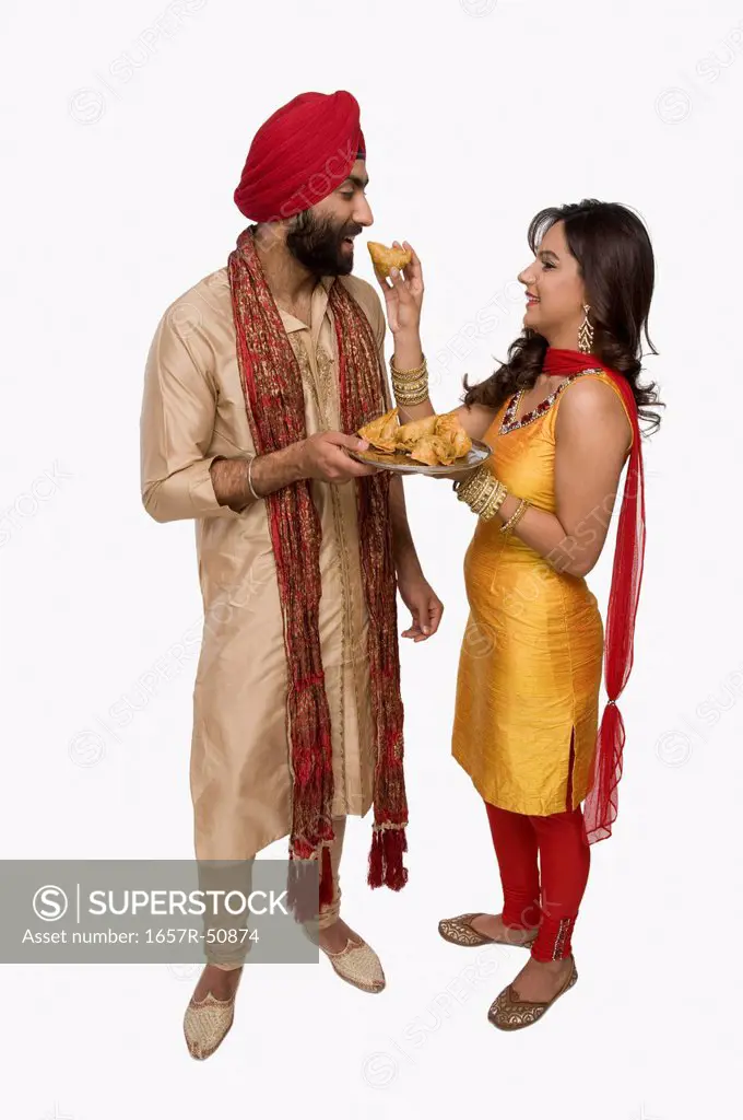 Woman feeding samosa to her husband