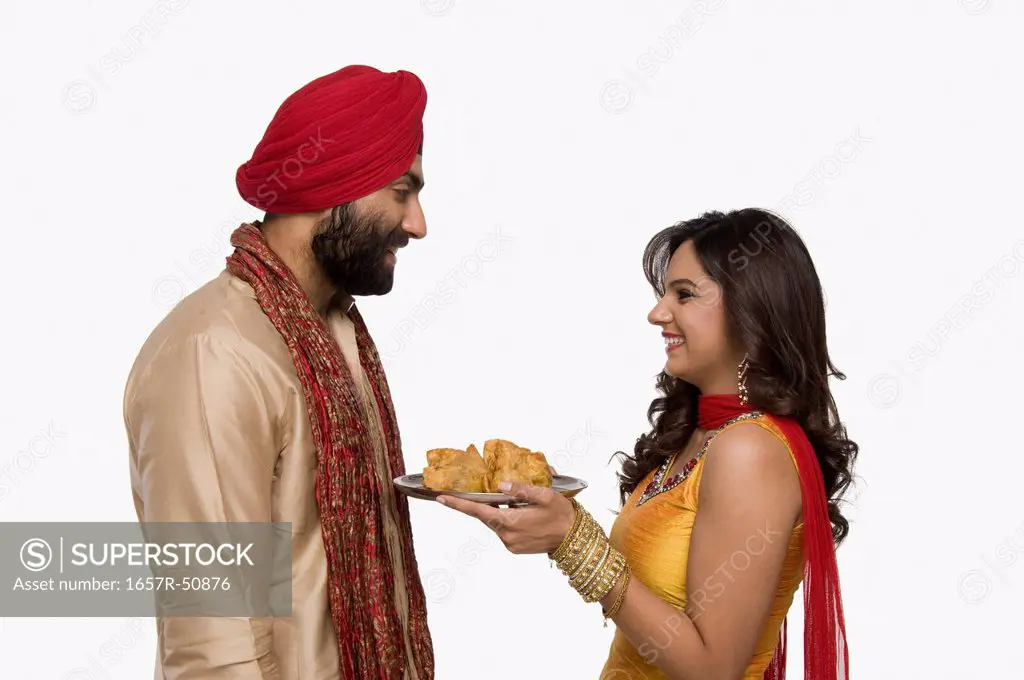 Woman offering samosa to her husband