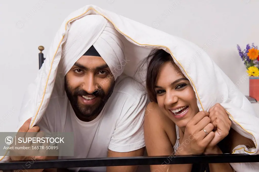 Sikh couple covering themselves with a blanket