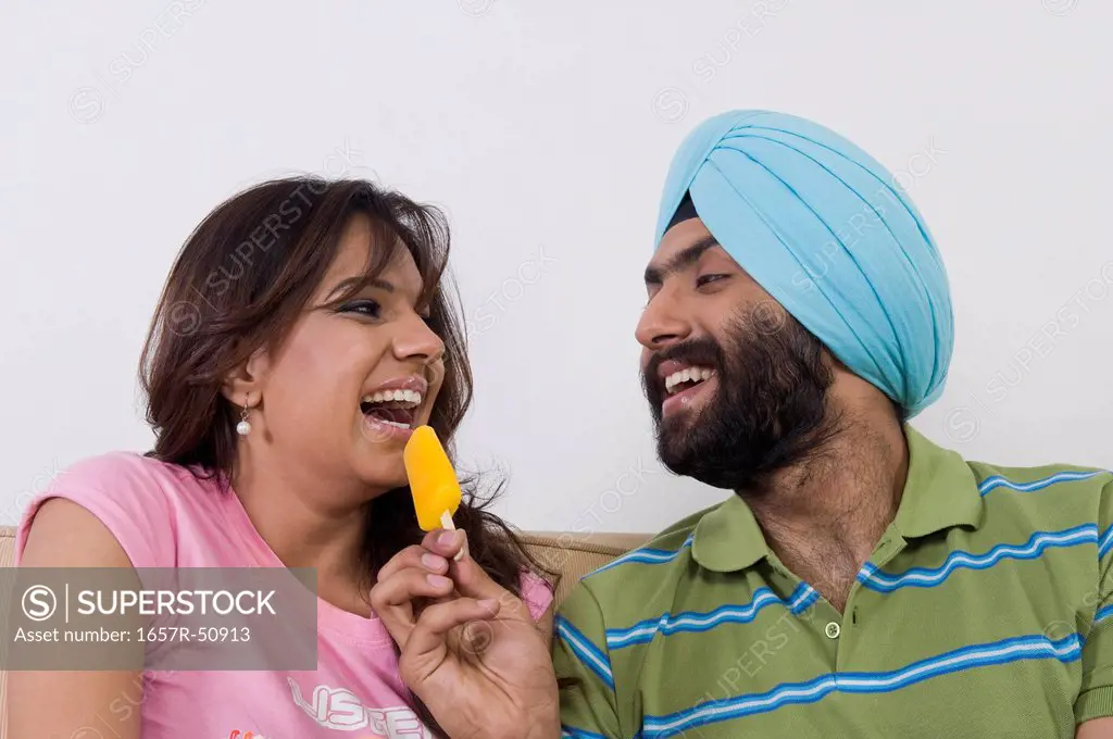 Sikh man feeding ice cream to his wife