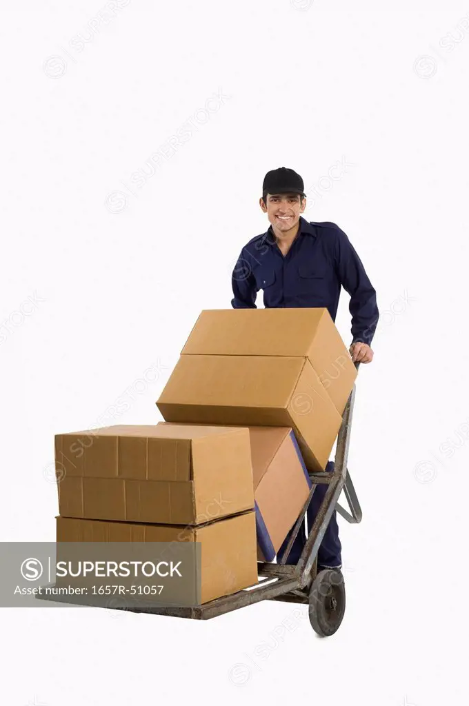 Delivery man pushing cardboard boxes on a hand truck