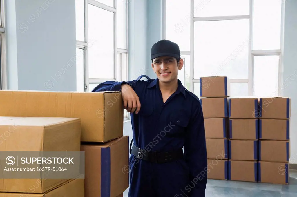 Delivery man with cardboard boxes in a warehouse