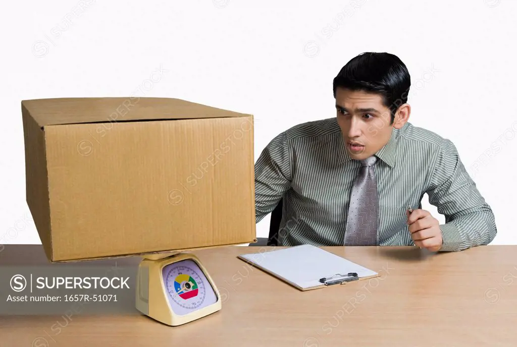 Man weighing a cardboard box and recording data