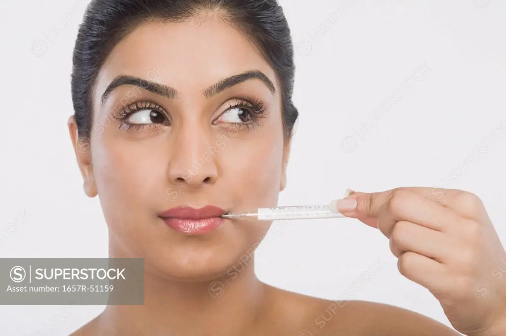 Woman holding a thermometer in her mouth
