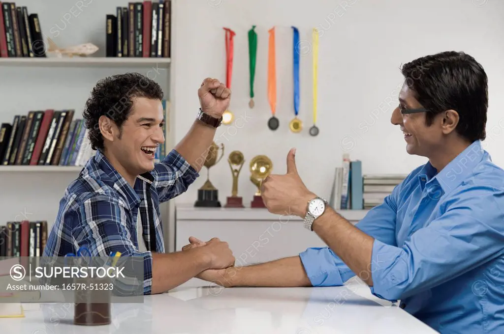 Man celebrating after defeat his father in arm wrestling