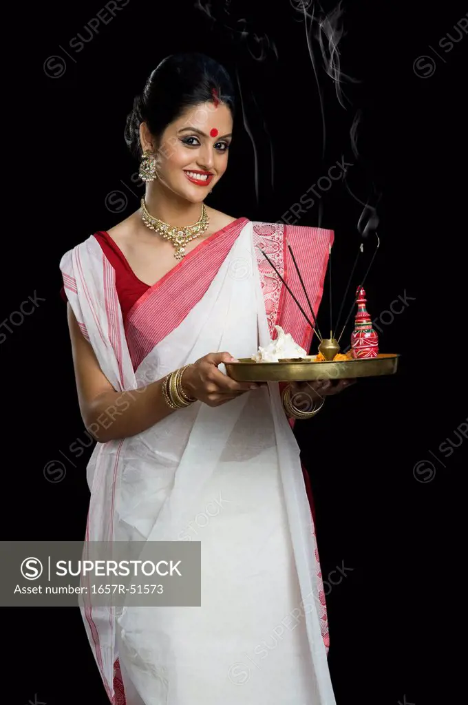 Indian woman in traditional clothing holding religious offering