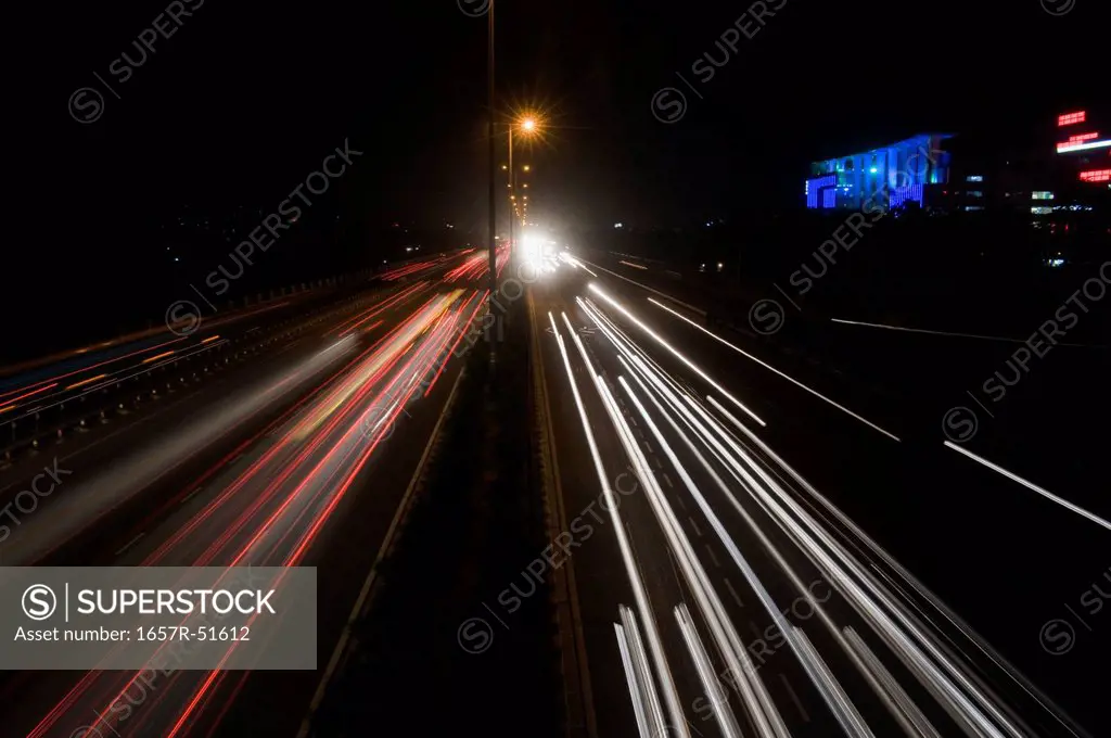 Streaks of lights of moving vehicles on the road, National Highway 8, Gurgaon, Haryana, India