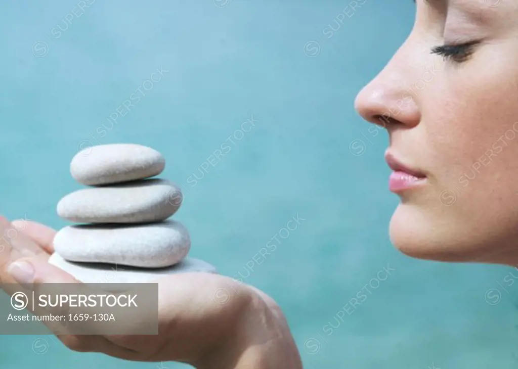 Close-up of a young woman holding a stack of pebbles