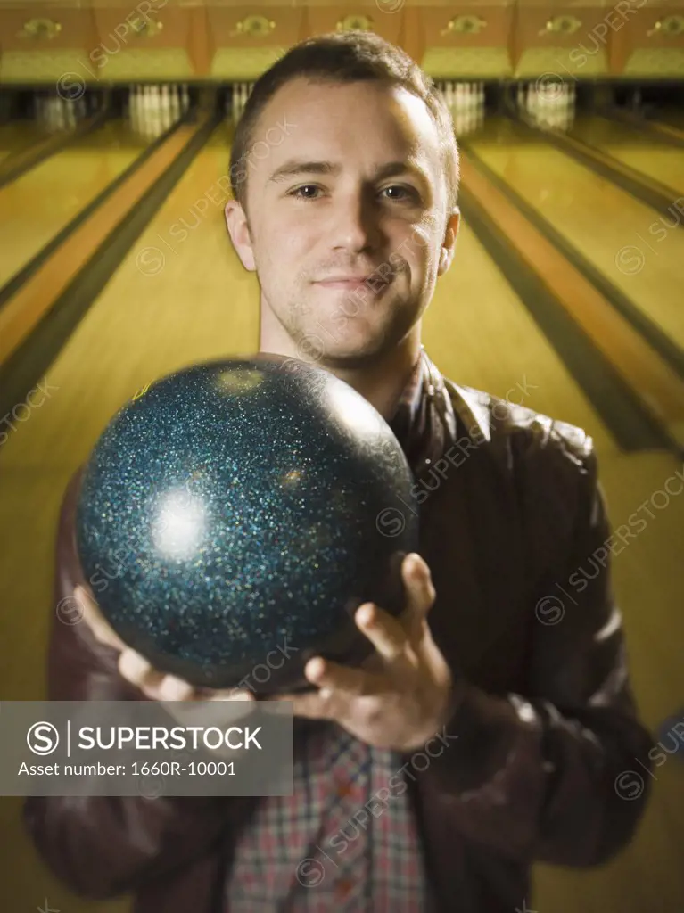 Portrait of a young man holding a bowling ball