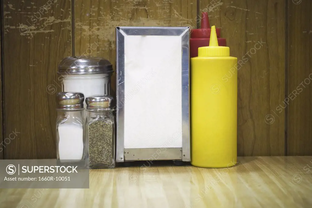 Pepper shaker and salt shaker with a napkin holder on a table in a restaurant