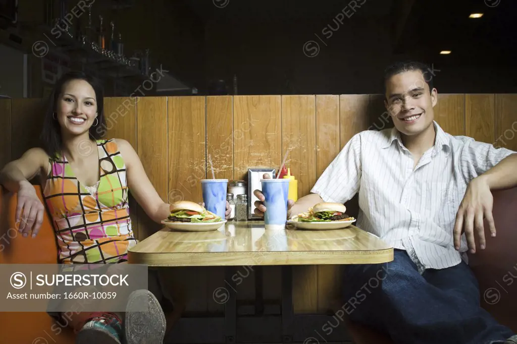 Portrait of a young man and a teenage girl sitting in a restaurant