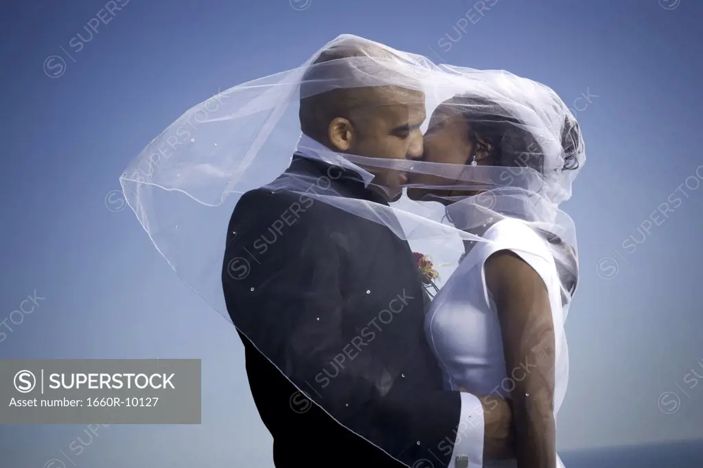 Profile of a newlywed couple kissing each other