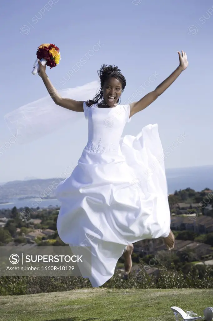 Portrait of a bride holding a bouquet of flowers and jumping