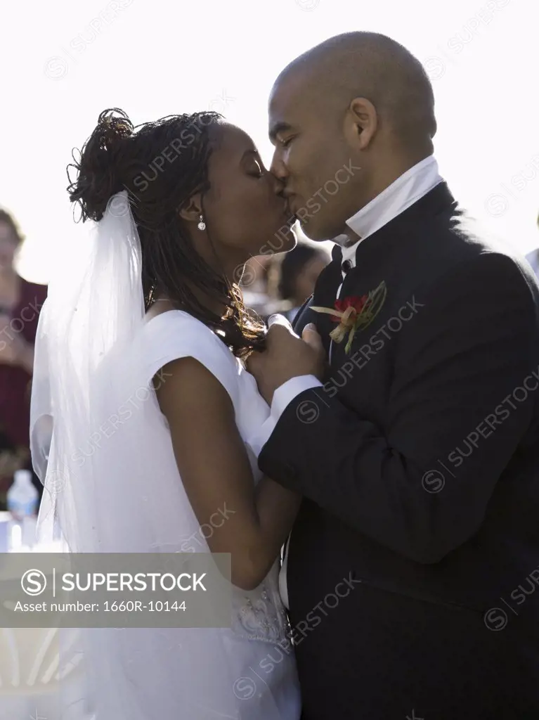 Profile of a bride and a groom kissing