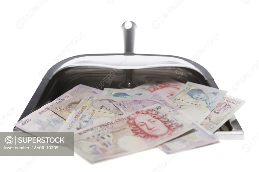 Close-up of British pounds in a dustpan