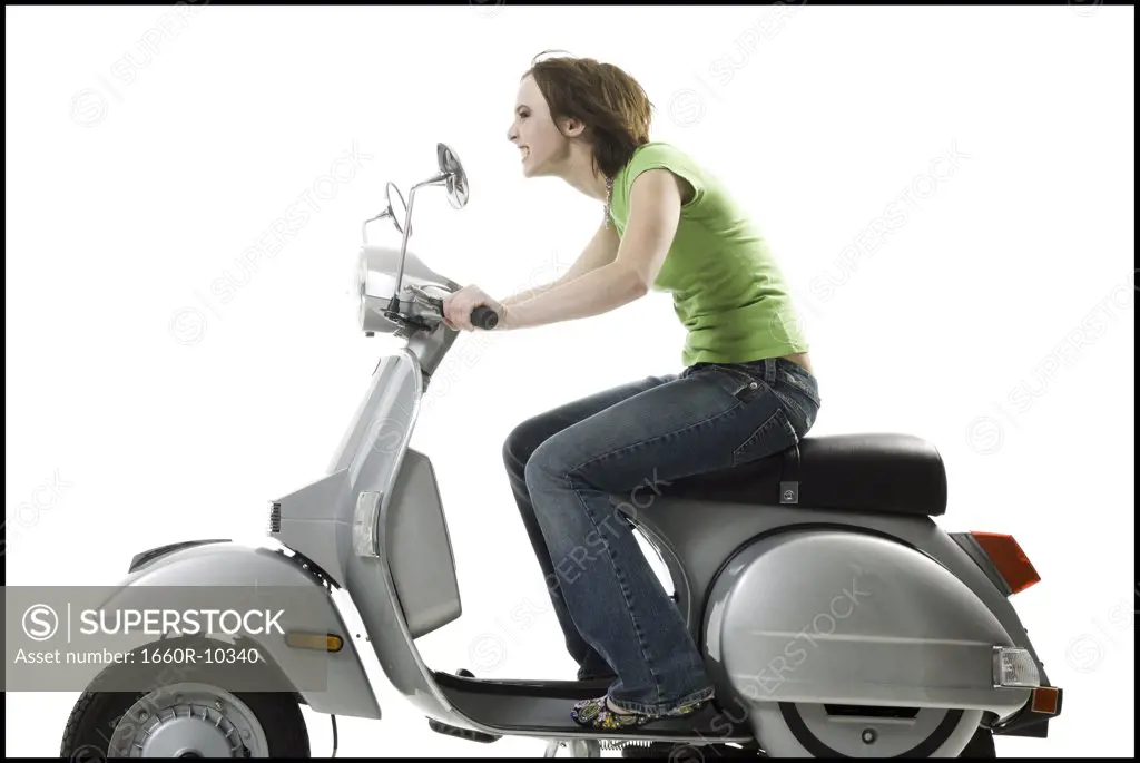 Profile of a teenage girl riding a scooter
