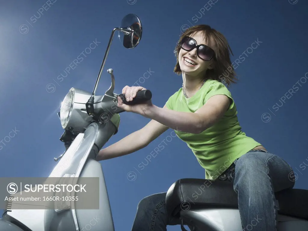 Close-up of a teenage girl riding a scooter